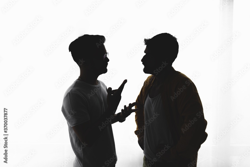 Silhouette of gay couple over white background
