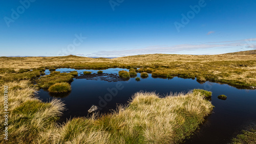 Blue sky reflecting in a mountain lake in Cairngorms National Park, Scotland. photo