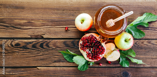 Rosh Hashanah. Jewish new year. Honey, pomegranate and apples on a wooden background. photo