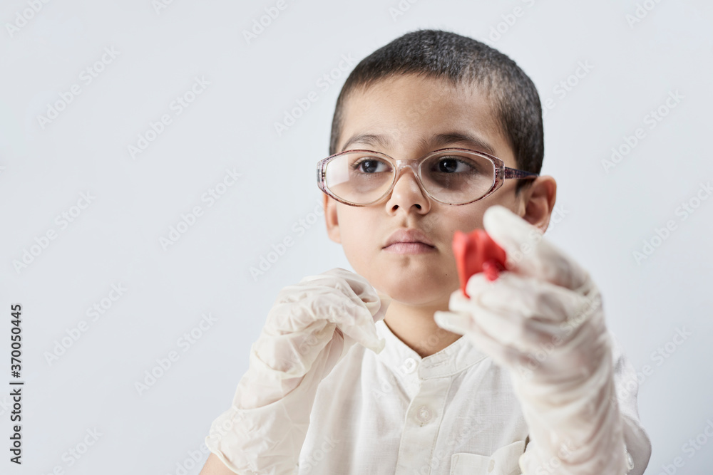 Portrait of a nerd boy in glasses playing with slime against the white background Portrait of a nerd boy in glasses playing with slime against the white background