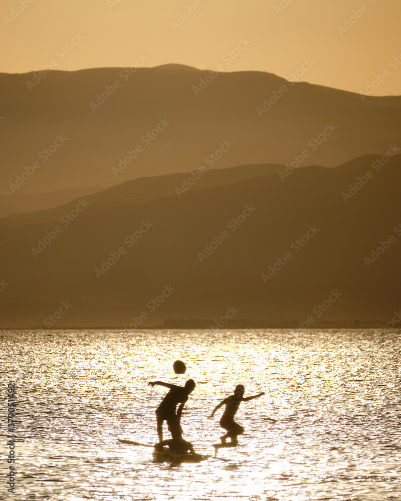 Fototapeta premium silhouette of kids playing in the sea during the sunset in Cabo de Gata, Almeria