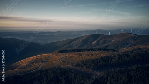 Aerial view of sunset over mountains and wind turbines