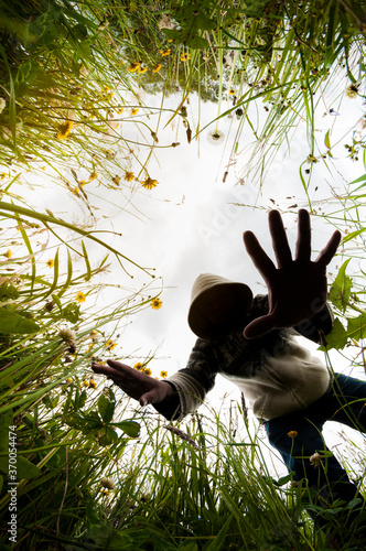 Slika na platnu man trying to grab something surrounded by plants and nature, nadir angle, nadir