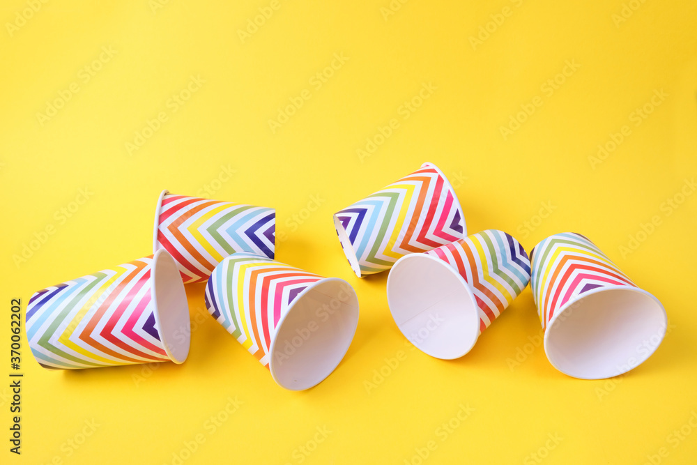 fallen paper holiday cups with geometric pattern on yellow background