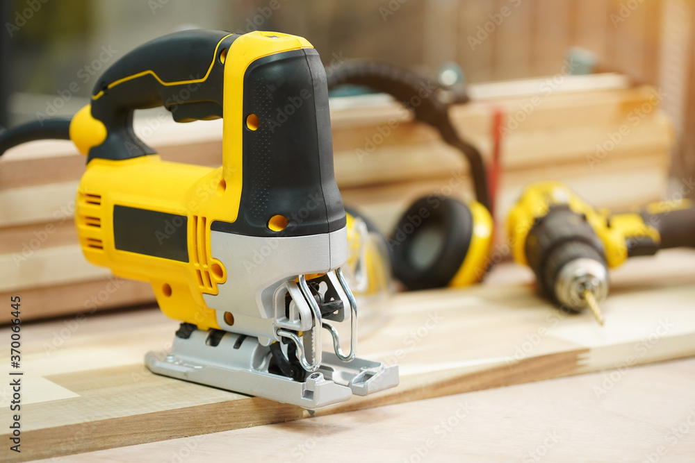 Power tool .Electric jig saw machine on Walnut Plywood in workshop, woodworking Handicraft and diy concept .selective focus Power tool .Electric jig saw machine on Walnut Plywood in workshop, woodworking Handicraft and diy concept .selective focus