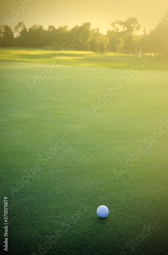 Fotografija White Golf Ball on the Green Facing the Sunset