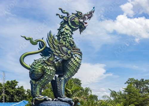 Chiangrai, Thailand - June 7, 2020: Blue Green Thai Lion on Blue Sky Background at Left Frame with Natural Light in Wat Rong Suea Ten at Chiangrai Thailand © steafpong