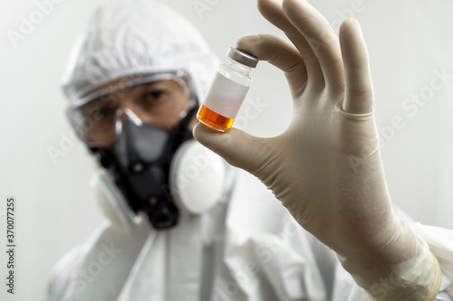 Health worker wearing personal protection equipment with vaccine