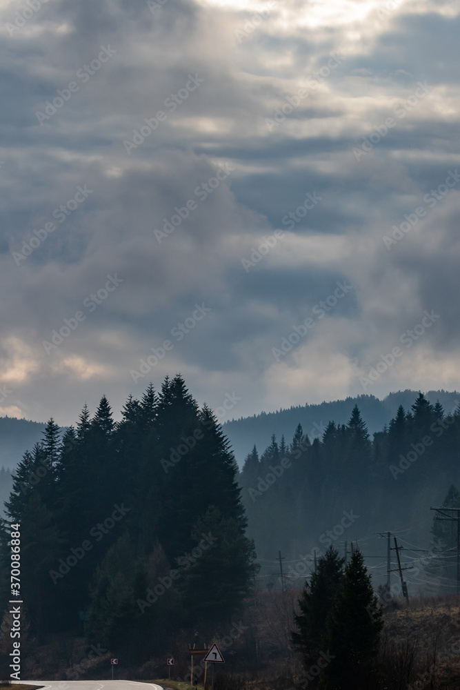 The tops of high mountains are hidden by clouds. Fog. Autumn landscape. Panoramic view.