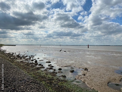 View of the broads National Park from the river bank in a cloudy day shoot taken against the sun with a dramatic sky and strong shadow in Great Yarmouth