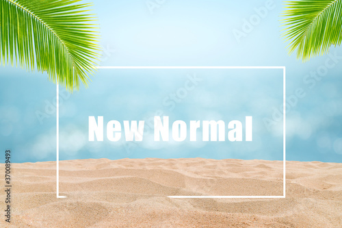 Fototapeta Naklejka Na Ścianę i Meble -  New Normal for Travel Concept : Wording text New Normal in white frame on sand beach with blurry seascape view in background.