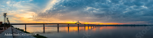 Panorama Beautiful sky on twilight time and reflection on the river and silhouette of the Second Thai–Lao Friendship Bridge of Thailand and   Laos. © noon@photo