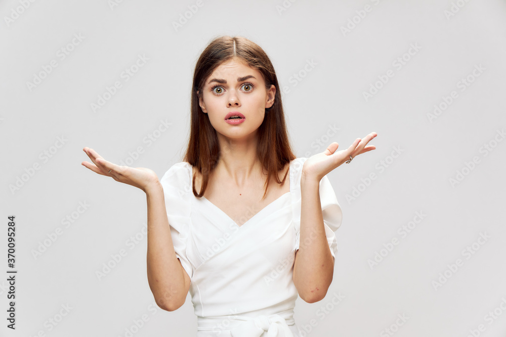 Emotional woman throws up her hands surprised look white dress cropped view Emotional woman throws up her hands surprised look white dress cropped view