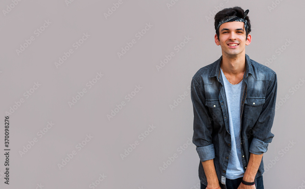 Closeup of happy smiling guy looking at camera isolated on gray background Closeup of happy smiling guy looking at camera isolated on gray background