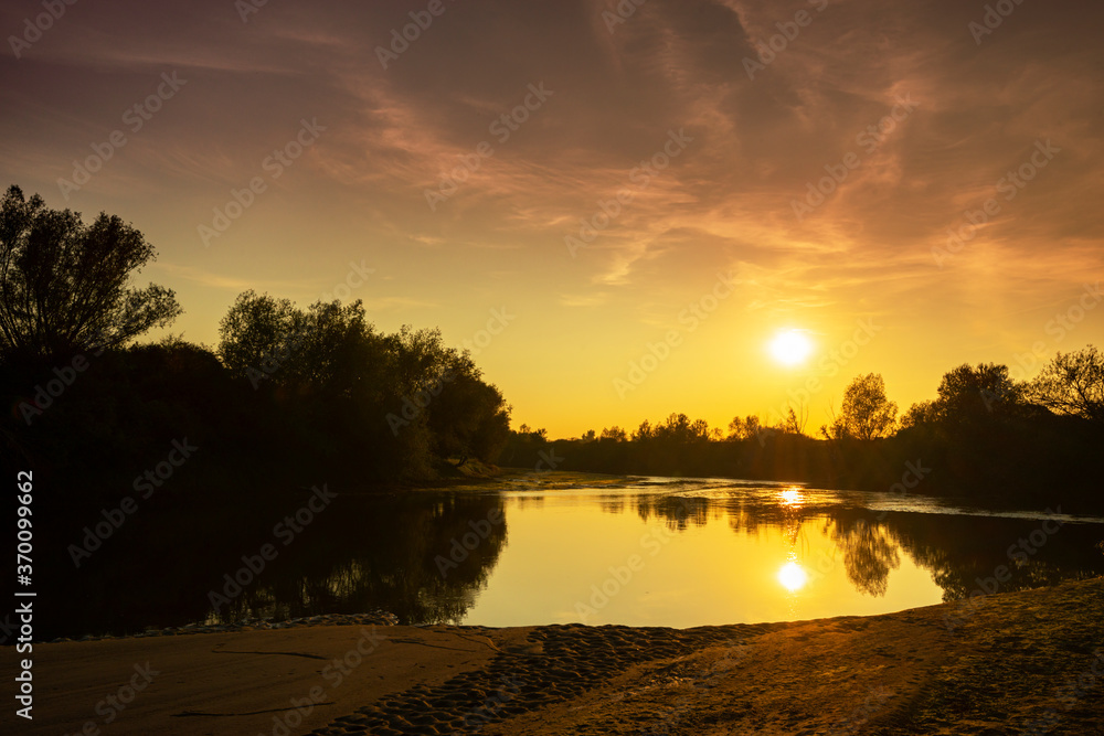 Obraz premium Wild, colorful sunset over tranquill river in a remote area in Europe