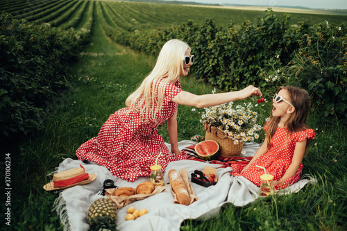 Canvas-taulu Young Mom with her Little Daughter Dressed Alike in Red Polka Dot Dress, Having