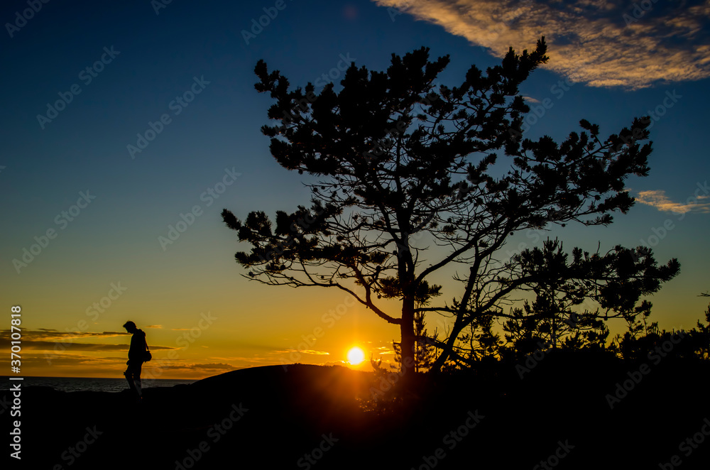 A man with a camera on the background of the sunset. Journey
