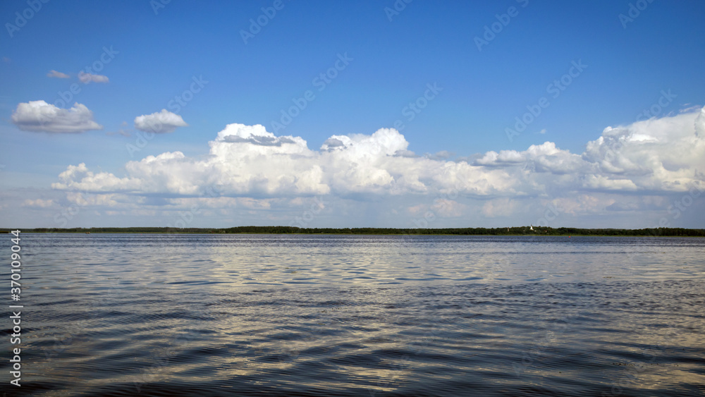 calm lake water surface, beautiful white cloud reflections in the water, sunny summer day