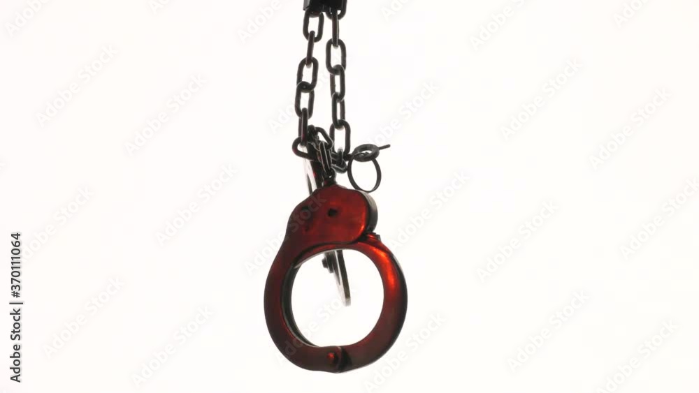 Steel handcuffs used in law enforcement and role-playing games. The video was shot in a backlight. Steel handcuffs used in law enforcement and role-playing games. The video was shot in a backlight.