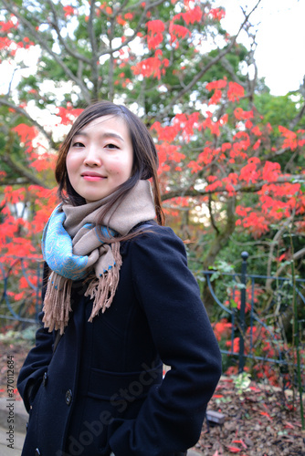 紅葉の前でポーズをとる女性
