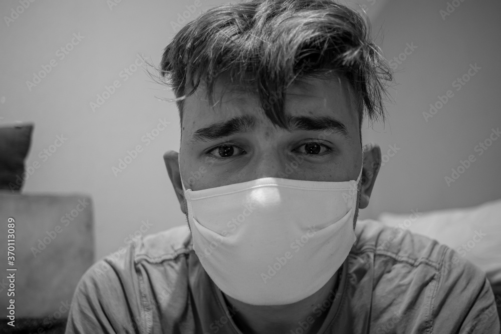 young-male-with-light-brown-hair-wearing-a-white-medical-mask-having-a