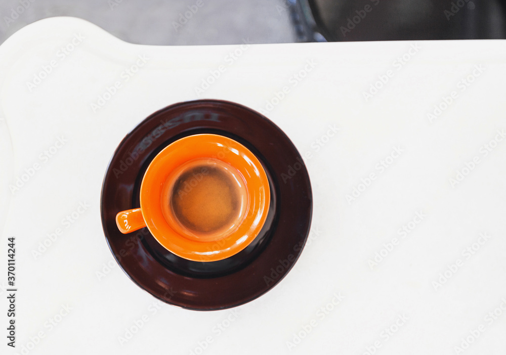 Orange cup of coffee on a table at cafe Orange cup of coffee on a table at cafe
