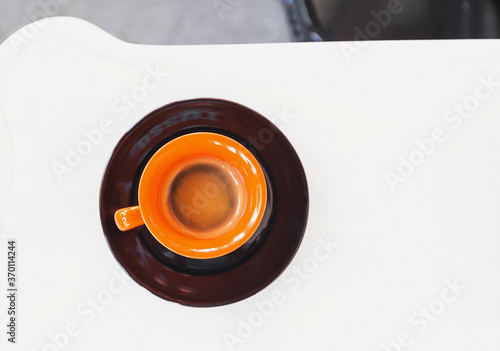 Orange cup of coffee on a table at cafe