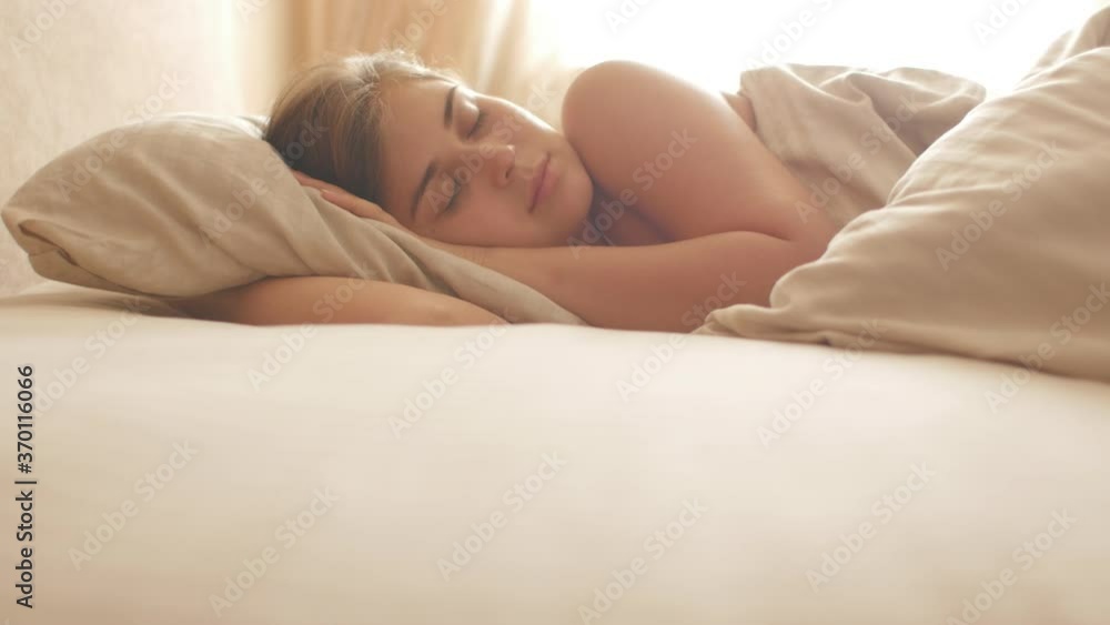 Calm young woman sleeping well in comfortable cozy bed on pillow, peaceful girl resting lying asleep in morning,crane shooting Calm young woman sleeping well in comfortable cozy bed on pillow, peaceful girl resting lying asleep in morning,crane shooting