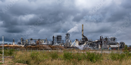 pipes of woodworking enterprise plant sawmill against a gloomy gray sky. Air pollution concept. Panorama of industrial landscape environmental pollution waste of thermal power plant