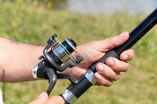 Man fisherman catches a fish.Fishing, spinning reel, fish. The concept of a rural getaway.