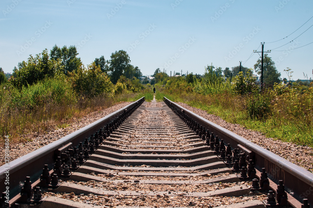 Fototapeta premium Railway tracks and gravel leading into the infinite distance