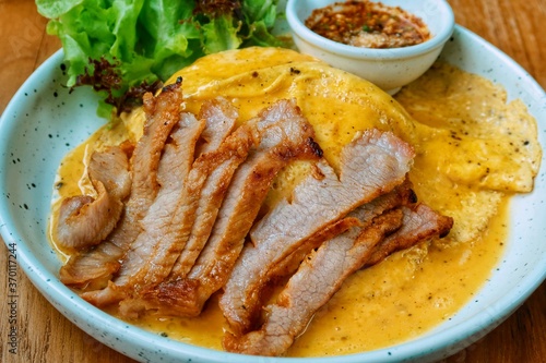 top view of grilled pork neck with omelette and spicy sauce