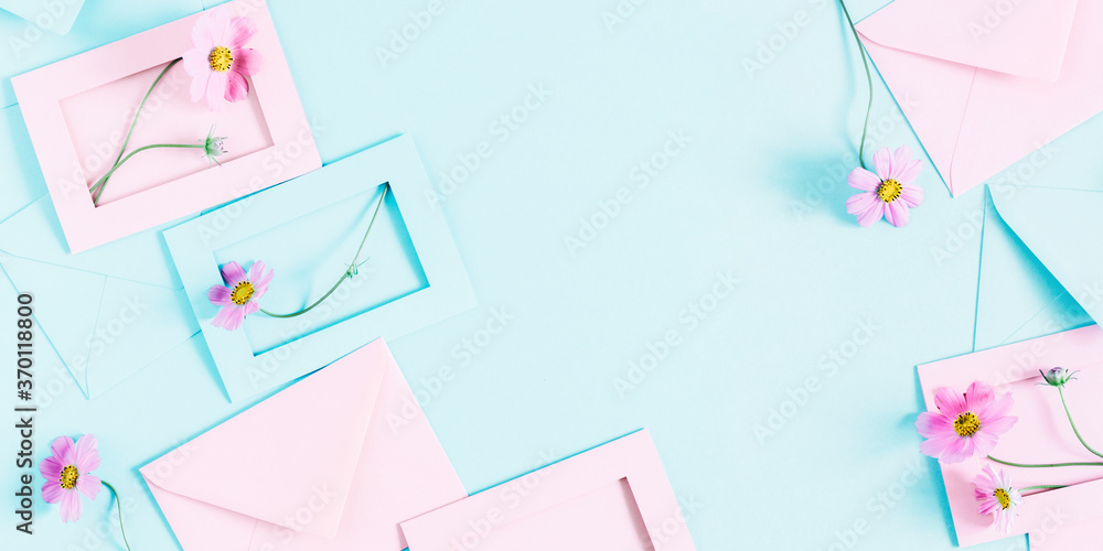 Flowers composition romantic. Pink cosmos flowers, pink and blue envelopes on pastel blue background. Flat lay, top view, copy space Flowers composition romantic. Pink cosmos flowers, pink and blue envelopes on pastel blue background. Flat lay, top view, copy space