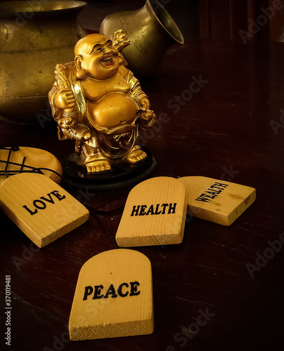 Laughing Buddha idol with pots in the background. The idol is a prestigious symbol in Buddhism.