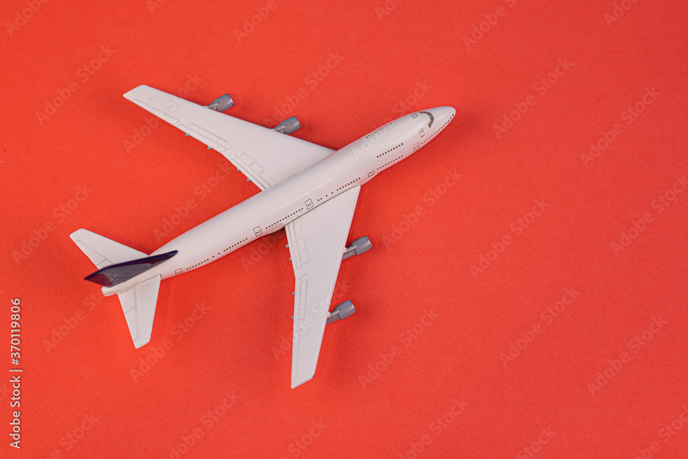 Concept of travel vacation. Top view white toy airplane isolated on red background with copy space. Minimal think.