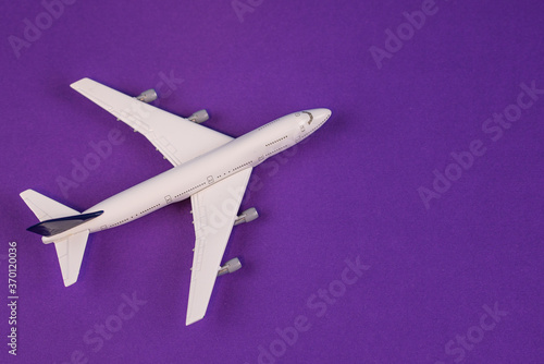 Concept of travel vacation. Top view white toy airplane isolated on green background with copy space. Minimal think.