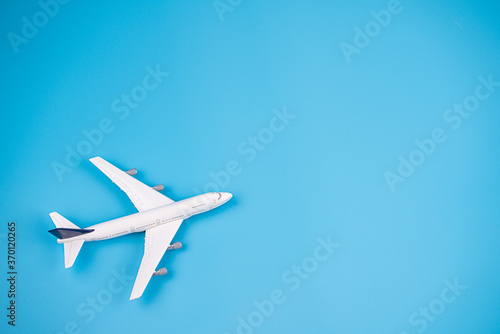 Concept of travel vacation. Top view white toy airplane isolated on blue background with copy space. Minimal think.