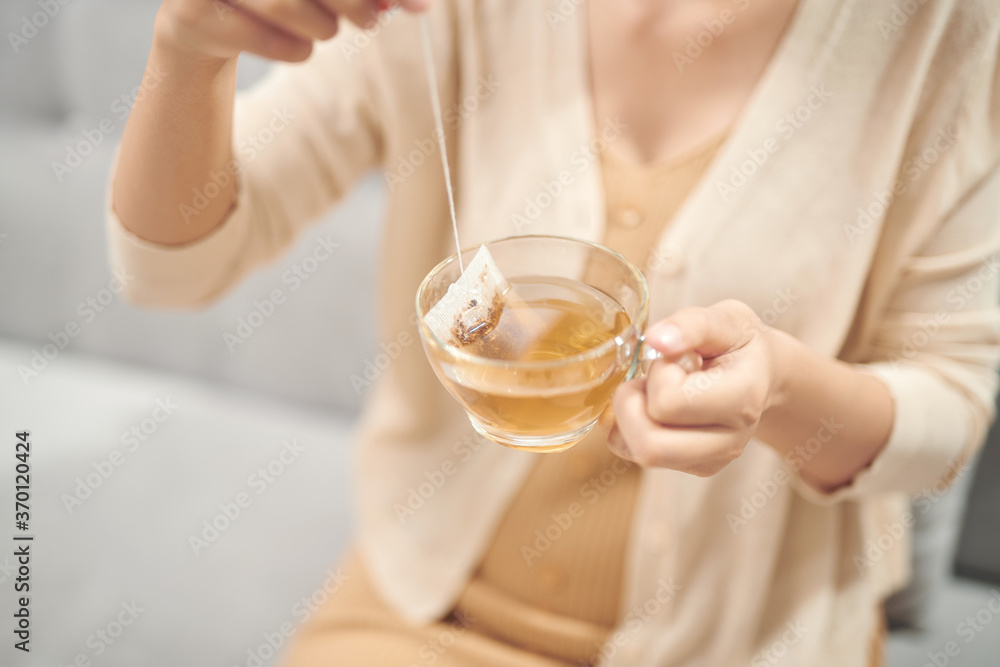 Indoor shot of a smiling asian woman drinking tea. Indoor shot of a smiling asian woman drinking tea.