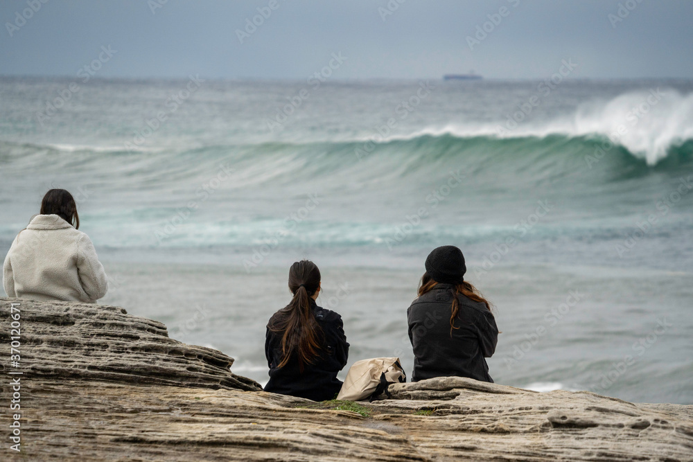 Ladies watching big surf from coastal cliffs, epic view Ladies watching big surf from coastal cliffs, epic view