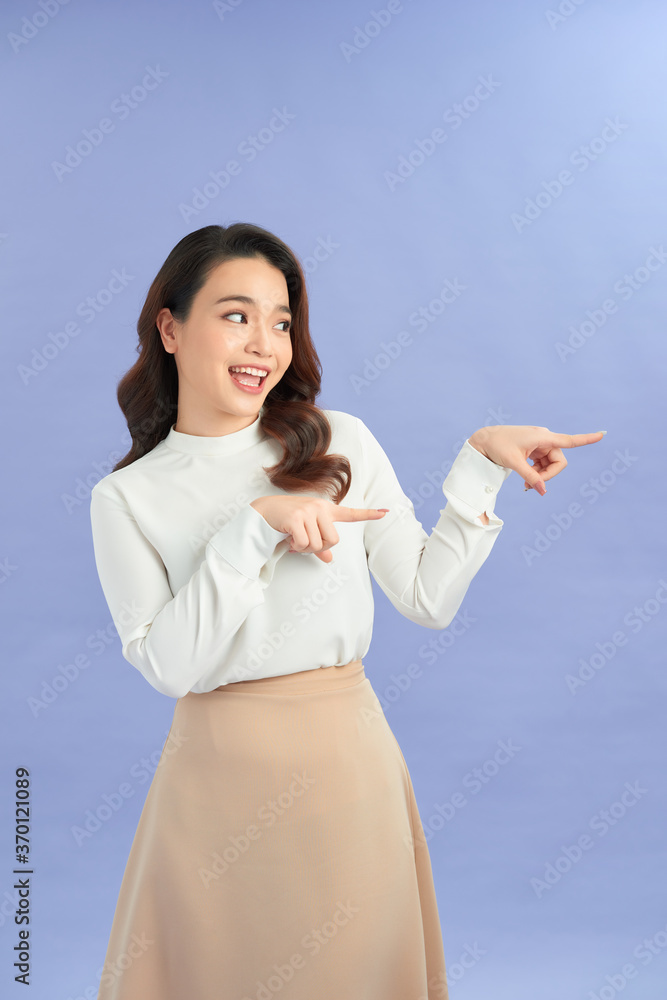 Young asian woman isolated on purple background shocked pointing with index fingers to a copy space. Young asian woman isolated on purple background shocked pointing with index fingers to a copy space.