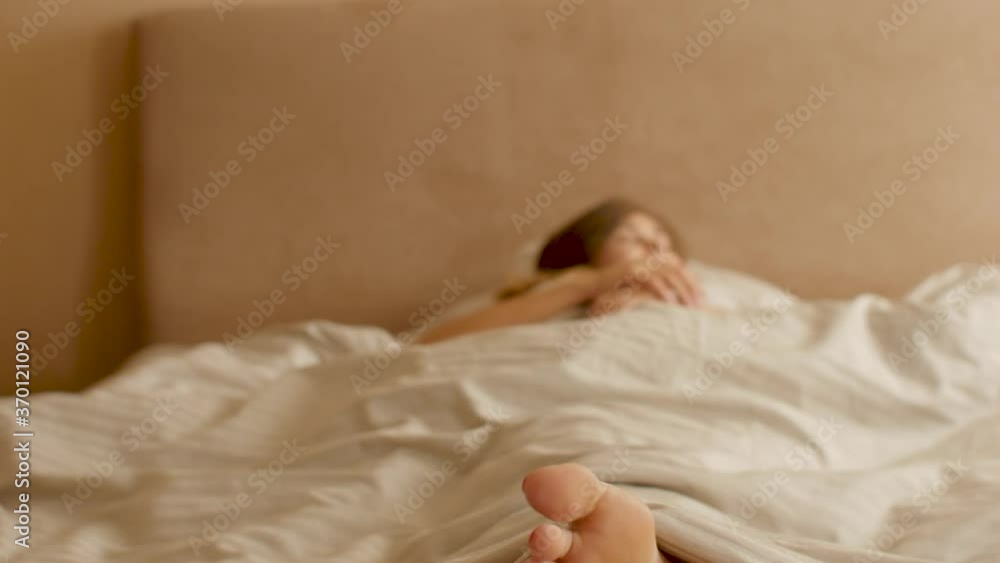 young woman awakening,sipping fingers on legs and stand up from bed, girl resting lying, morning routine young woman awakening,sipping fingers on legs and stand up from bed, girl resting lying, morning routine