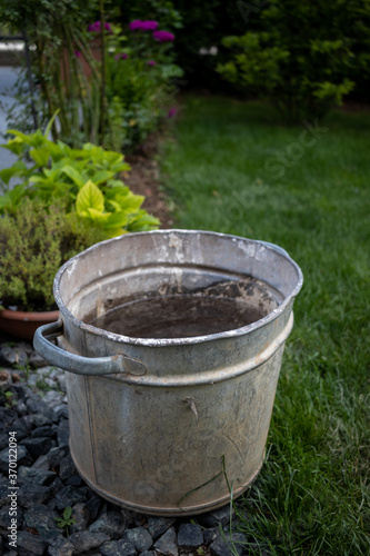 Metal bucket filled with water and dirt on the bottom of it in a park AM © Hamza