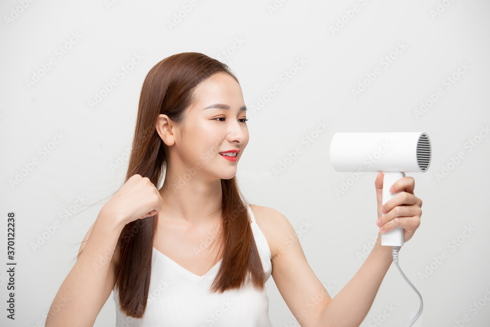 Attractive beautiful Asian woman blowing the wind by hair dryer Attractive beautiful Asian woman blowing the wind by hair dryer