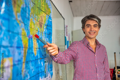 Fotografia, Obraz Happy confident teacher explaining geography lesson at school