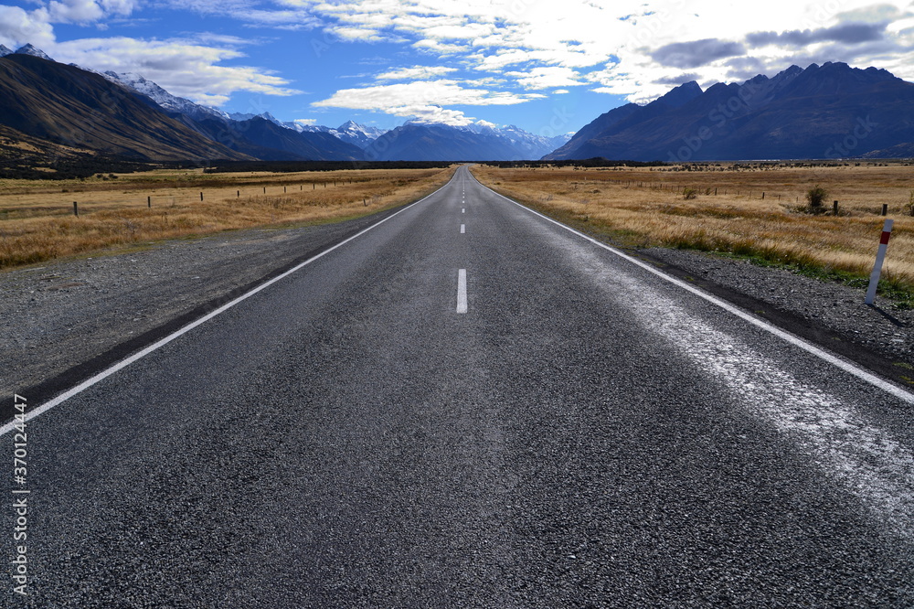 Straight road leading towards a snow capped mountain in New Zealand Straight road leading towards a snow capped mountain in New Zealand