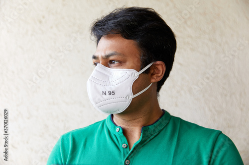 Adult wearing White N 95 Mask looking and facing 45 degrees to the right