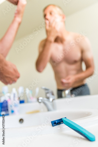 Homme se rasant devant un miroir à l'hôtel