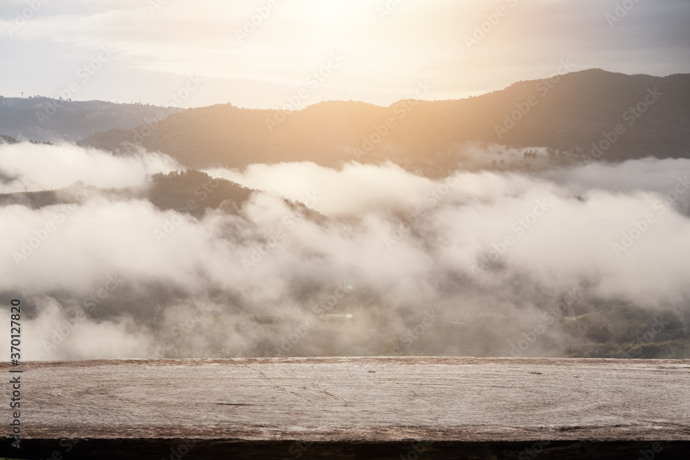 Fototapeta premium wooden panel table top with the mountain with fog landscape background. for montage product display or design key visual layout. .