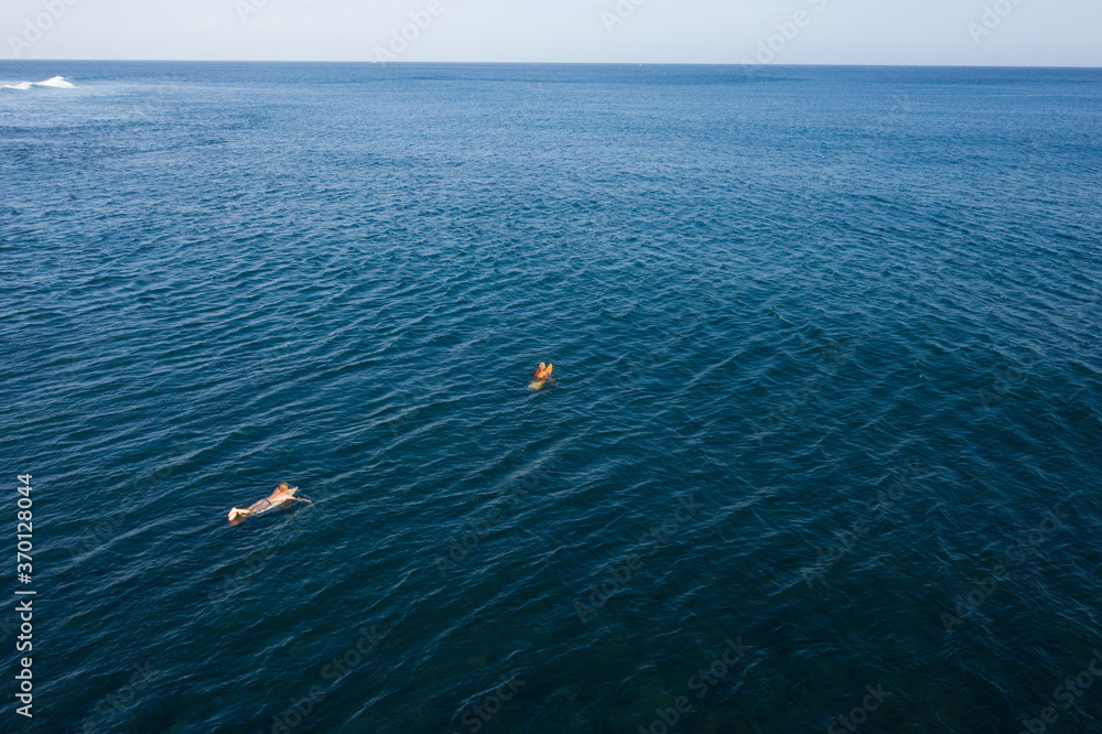 Aerial view of surfers in tropical ocean waiting for waves. Bali, Indonesia Aerial view of surfers in tropical ocean waiting for waves. Bali, Indonesia