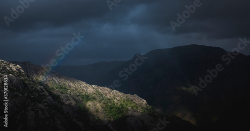 Paisagem natural dramática de raio de sol montanhas e arco íris